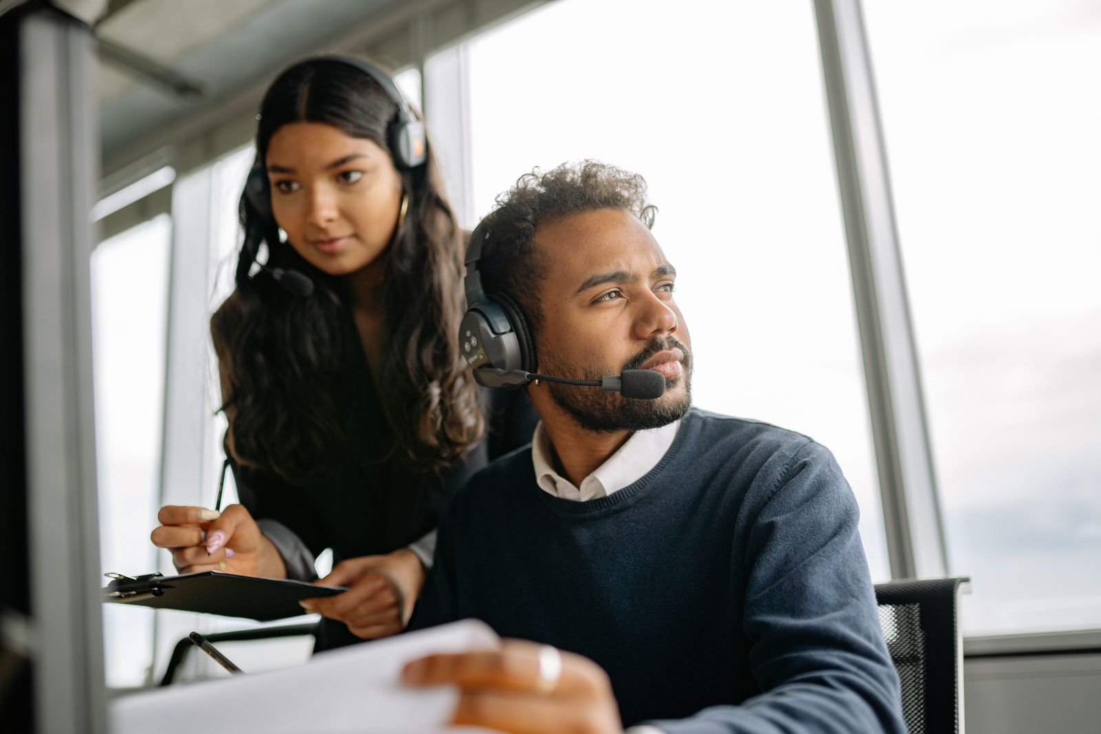 Zwei Personen mit Headsets in einem Büro