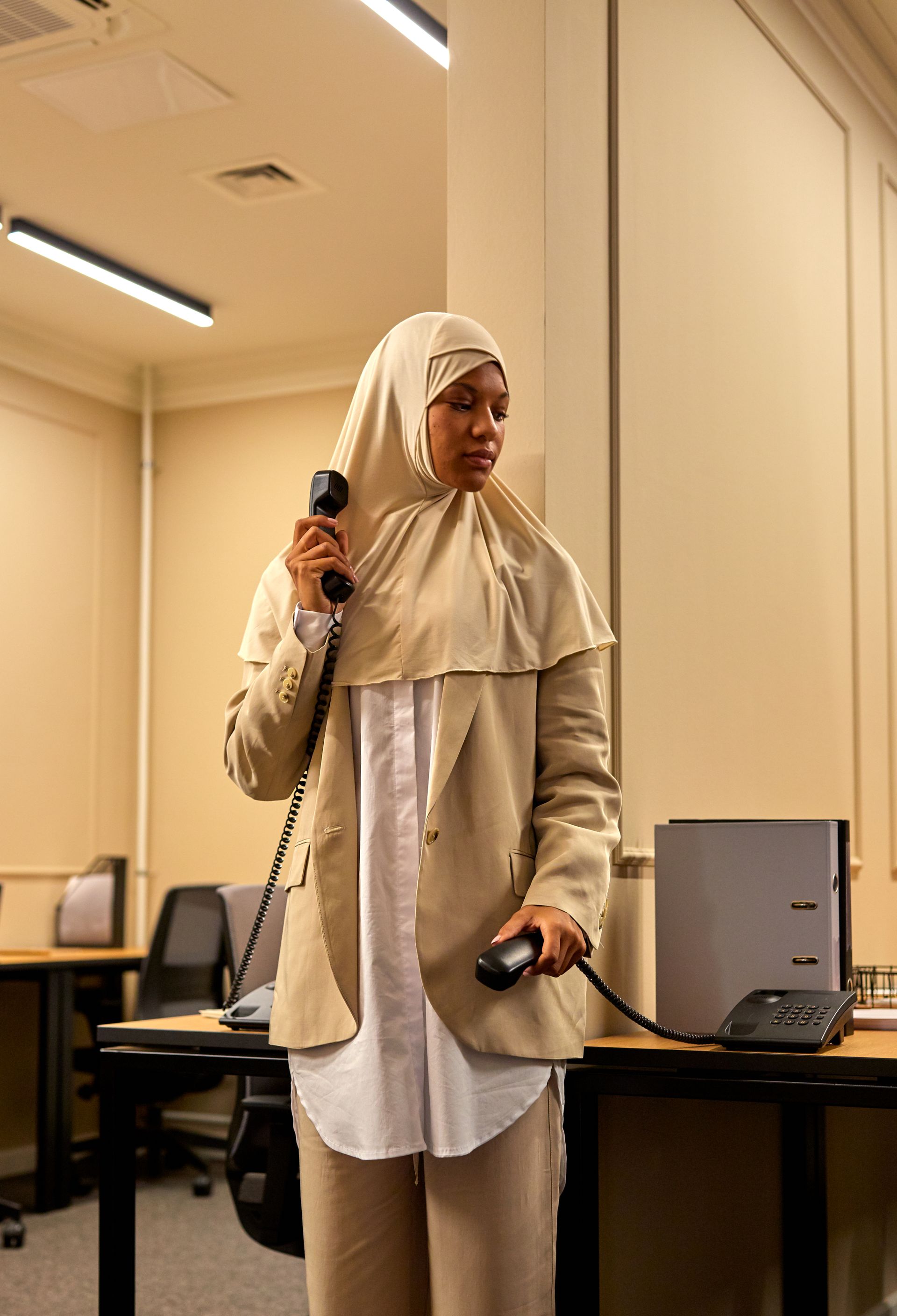 Person mit Headset und Telefonen in einem Büro